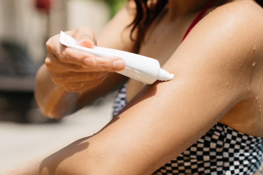 mujer con bloqueador en el brazo